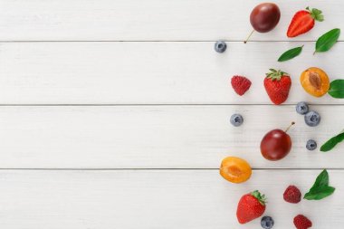 Beyaz ahşap masa üstü görünümünde çeşitli meyveler