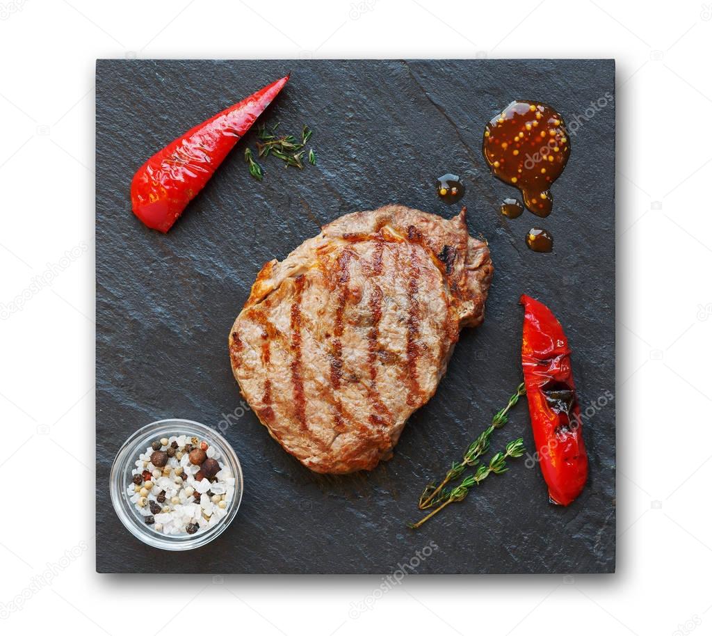 Grilled beef steak and pepprs isolated on white