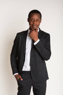 Takım elbiseli, ayakta güçlü siyah işadamı kravat düzeltiyor