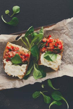 Bruschetta peynir ve siyah arka plan üzerine sebze ile