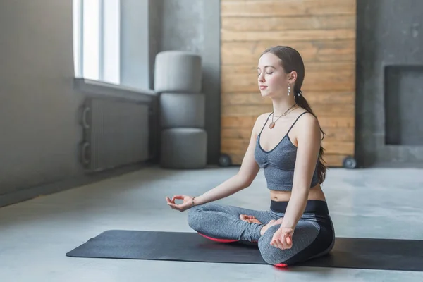Mujer joven en clase de yoga, relajar la meditación pose —  Fotos de Stock