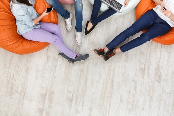 Amigos usando gadgets, sentados en el interior en línea — Foto de Stock