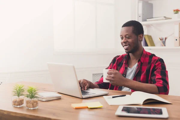 Щасливий чорний бізнесмен в казуальному офісі, робота з ноутбуком — стокове фото