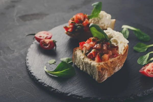 Bruschetta peynir ve siyah arka plan üzerine sebze ile
