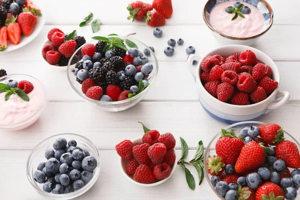 Hälsosam frukost med bär och yoghurt på vitt trä bord — Stockfoto