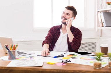 Cep telefonu üzerinde konuşurken neşeli genç işadamı