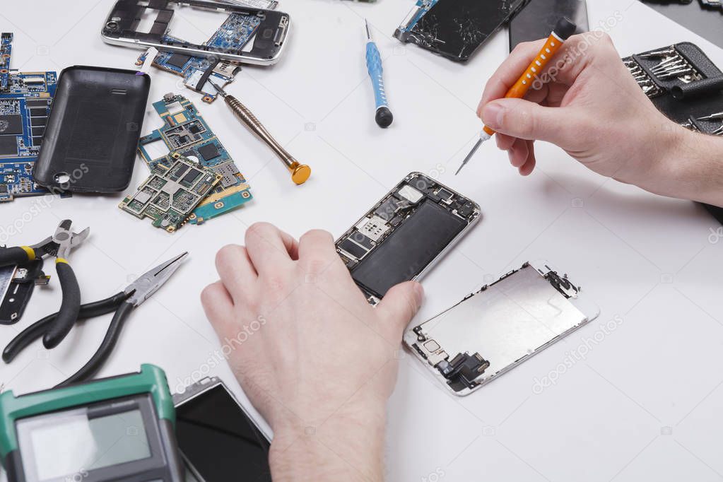 Repairman disassembling phone with screwdriver