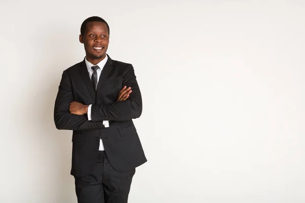 Усміхнений чорний чоловік-менеджер у костюмі стоїть з схрещеними руками. Портрет — стокове фото