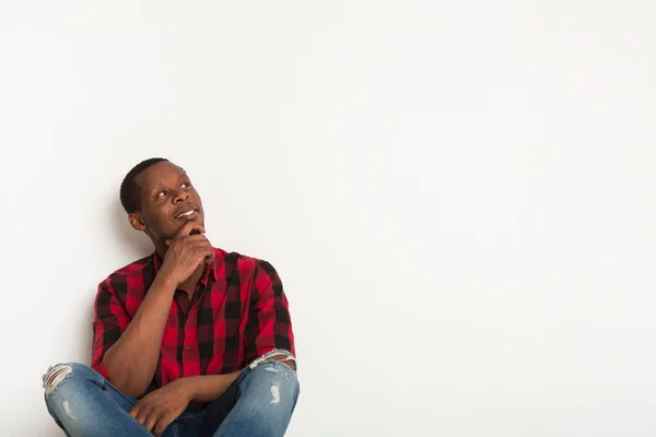 Fundersam ung svart man på studio bakgrund — Stockfoto