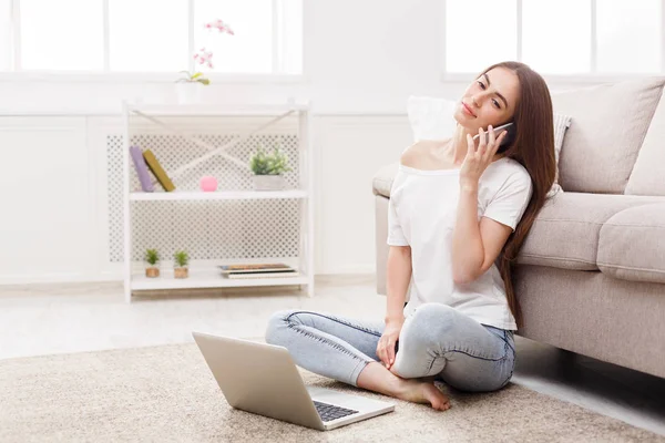 Jonge gelukkige vrouw met laptop en smartphone — Stockfoto