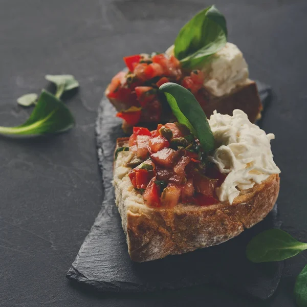 Bruschetta peynir ve siyah arka plan üzerine sebze ile