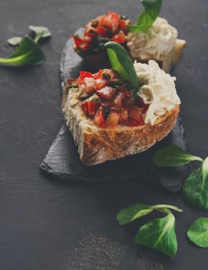 Bruschetta peynir ve siyah arka plan üzerine sebze ile