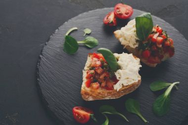 Bruschetta peynir ve siyah arka plan üzerine sebze ile