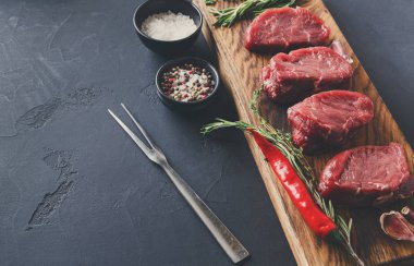 Fileto biftek ve siyah arka plan, ahşap baharat