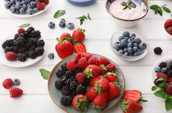 Hälsosam frukost med bär och yoghurt på vitt trä bord — Stockfoto