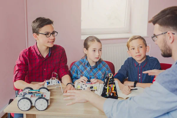 Stem education. Kids creating robots with teacher — Stock Photo, Image