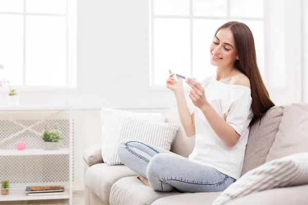 Happy girl with pregnancy test at home — Stock Photo, Image