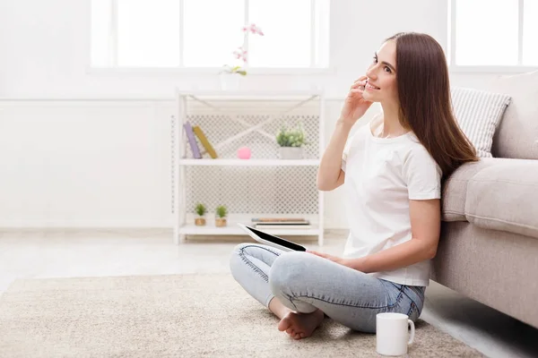 Jovem mulher feliz com um tablet falando no celular . — Fotografia de Stock