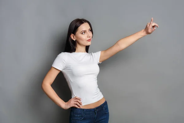 Mujer emocionada muestra algo, señalar con el dedo hacia arriba —  Fotos de Stock