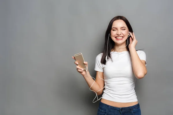 Mulher com olhos fechados curtindo música em fones de ouvido — Fotografia de Stock