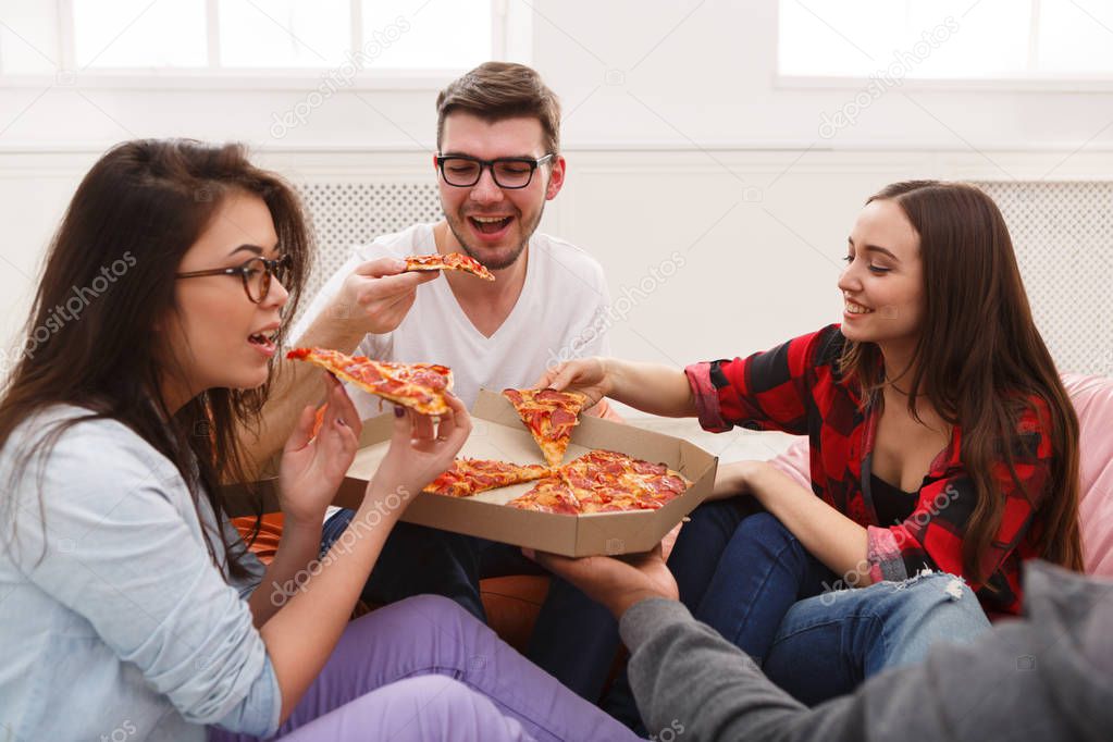 Students sharing pizza at home party
