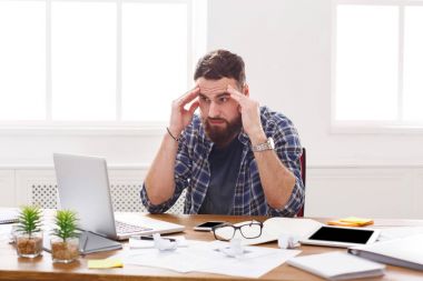 Genç işadamı modern beyaz ofis içinde laptop ile vurguladı