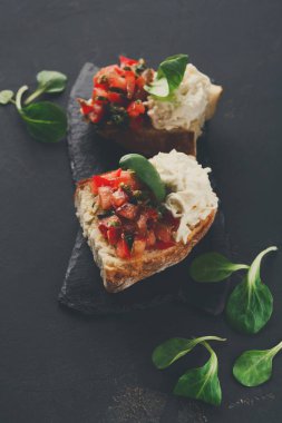 Bruschetta peynir ve siyah arka plan üzerine sebze ile