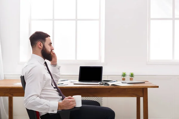 Ernstige zakenman praten op mobiele telefoon met laptop in moderne kantoren — Stockfoto