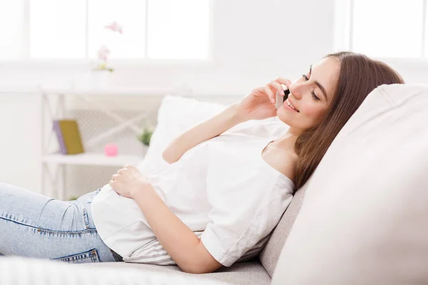 Young girl talking on mobile on sofa — Stock Photo, Image