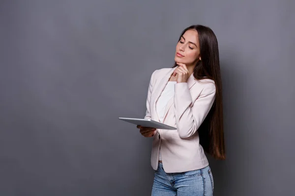 Mujer con tableta sobre fondo gris — Foto de Stock