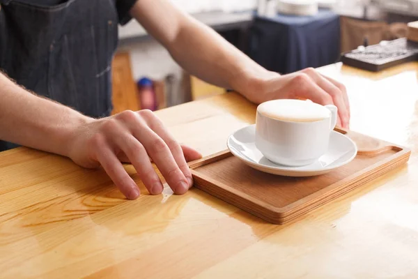 Barman servindo xícara de café no balcão de madeira — Fotografia de Stock