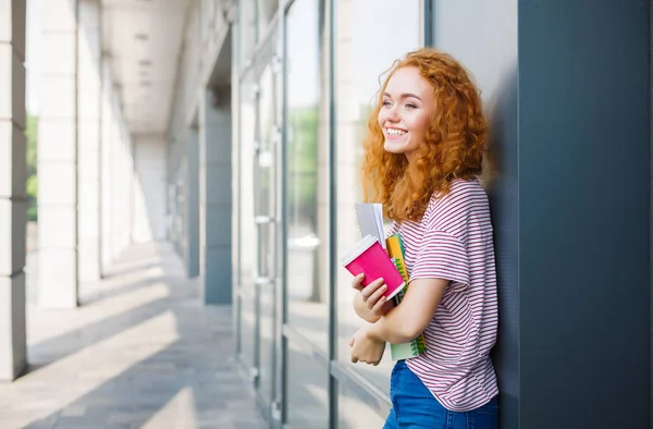 Genç gülümseyen Kızıl saçlı öğrenci kızla fincan kahve ve kitaplar — Stok fotoğraf