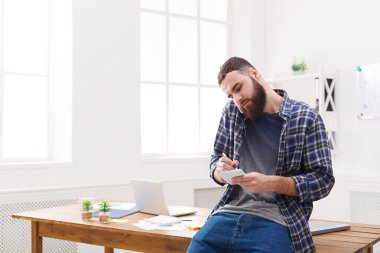 Meşgul genç işadamı konuşmak telefon ofis