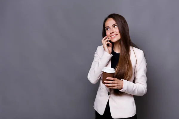 Mosolyogva üzleti nő beszélő mobiltelefon, és kávét iszik, a munka — Stock Fotó