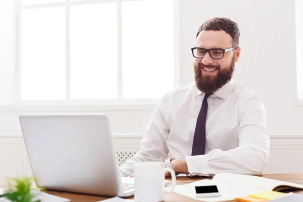 Glad och avslappnad affärsman med laptop i modern vit office — Stockfoto