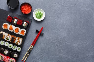 Üstten Görünüm suşi maki ve rulo rustik gri arka plan üzerinde kümesi