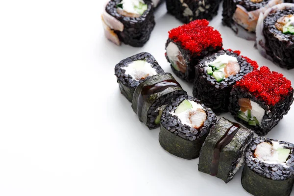 Portre siyah suşi ayarla, maki unagi soslu beyaz zemin üzerine alır.