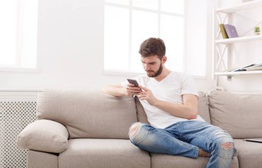 Genç adam evde cep telefonu mesajlaşma