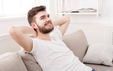 Yakışıklı genç adam evde kanepede rahatlatıcı