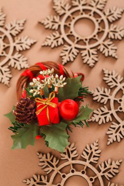 Ahşap kar taneleri, bej renkli arka plan üzerinde Center'da yaratıcı çelenk. Dikey