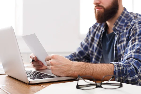 Young geconcentreerd zakenman Lees documenten in moderne witte office — Stockfoto