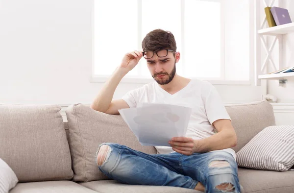 Jovem empresário cansado leitura relatório em casa — Fotografia de Stock