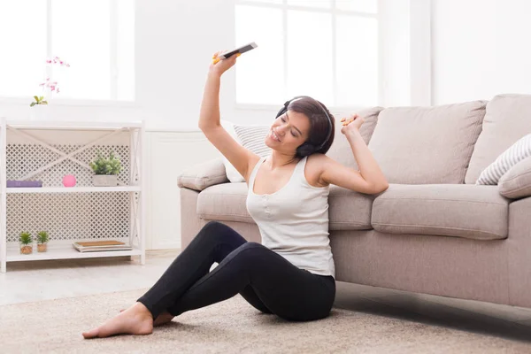 Young woman enjoying her favorite song in earphones — Stock Photo, Image