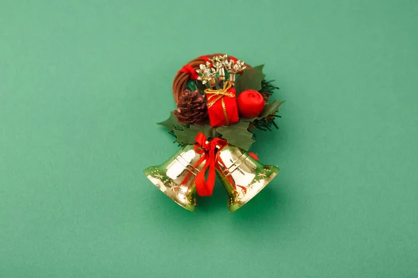 Ręcznie robione wieniec i Boże Narodzenie dzwony na zielonym tle — Zdjęcie stockowe