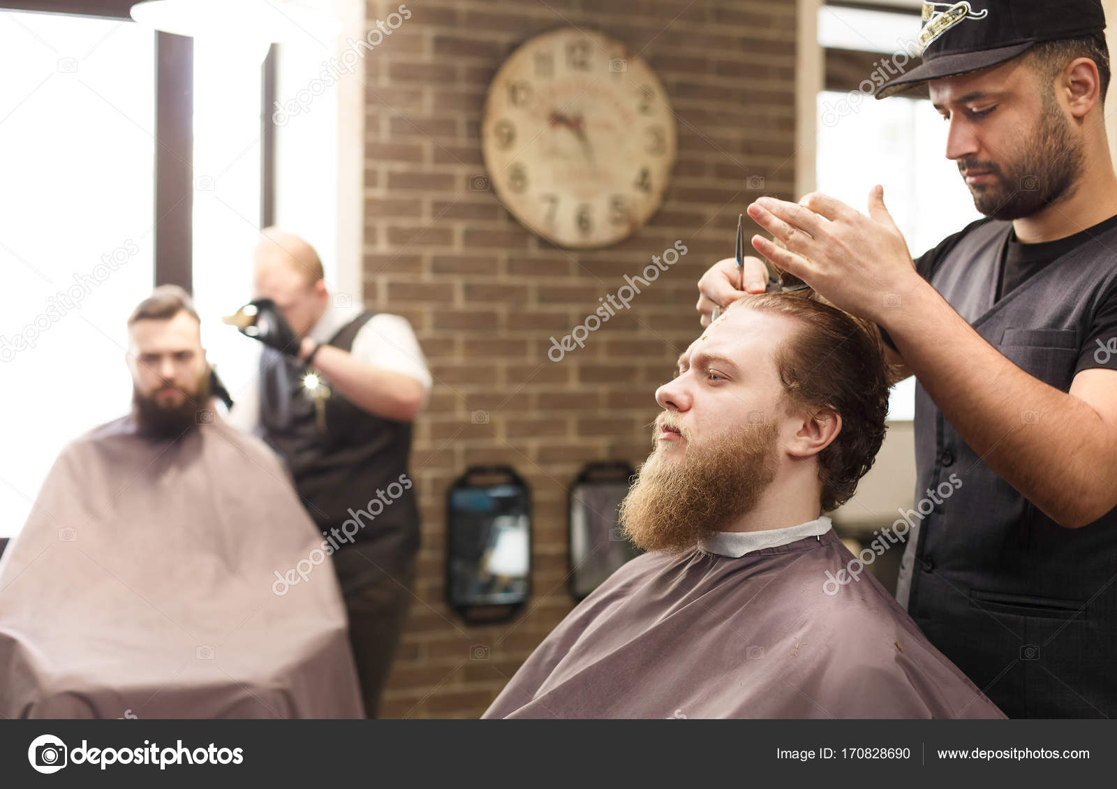 Man Getting Haircut By Hairstylist At Barbershop Stock Photo