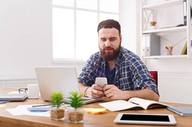 Cep telefonu tarafından dizüstü bilgisayar kullanarak Office genç işadamı