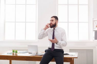 Formal giyim işadamı mobil telefon modern beyaz ofisinde konuşmak vardır