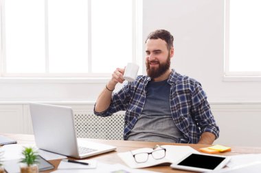 Modern beyaz ofis içinde laptop ile mutlu işadamı