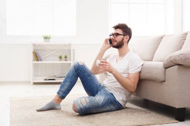 Mobile ile evde gözlük gülümseyen adam