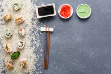 Suşi roll, maki rustik gri ve pirinç zemin üzerine dizi görünüm üstte